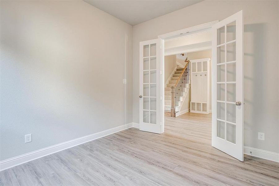 Spare room with french doors and light wood-type flooring