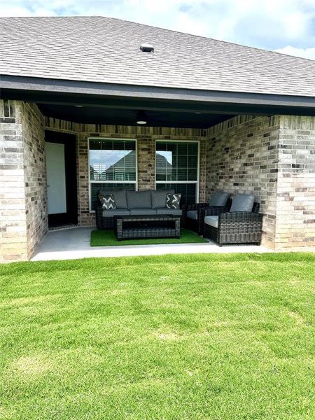 Rear view of property with an outdoor living space, a yard, and roof with shingles Rear view of property with an outdoor living space, a yard, and roof with shingles