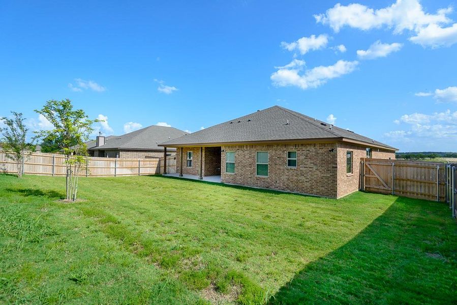 Rear view of property with brick siding, a fenced backyard, a patio, and roof with shingles Rear view of property with brick siding, a fenced backyard, a patio, and roof with shingles