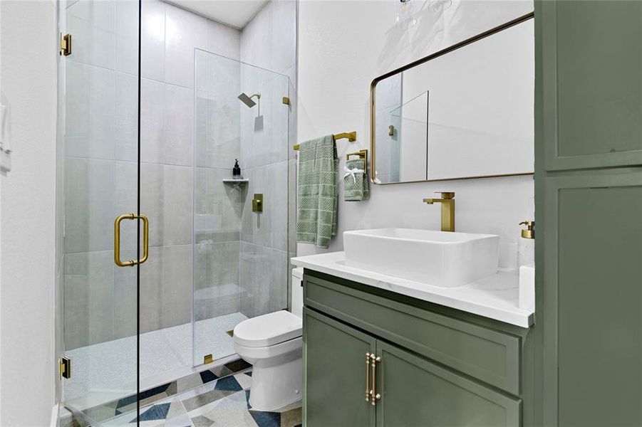 Ensuite bathroom in the 2nd bedroom, with vanity and a walk in shower. Tile wall shower with custom cabinets and gold fixtures. Ensuite bathroom in the 2nd bedroom, with vanity and a walk in shower. Tile wall shower with custom cabinets and gold fixtures.