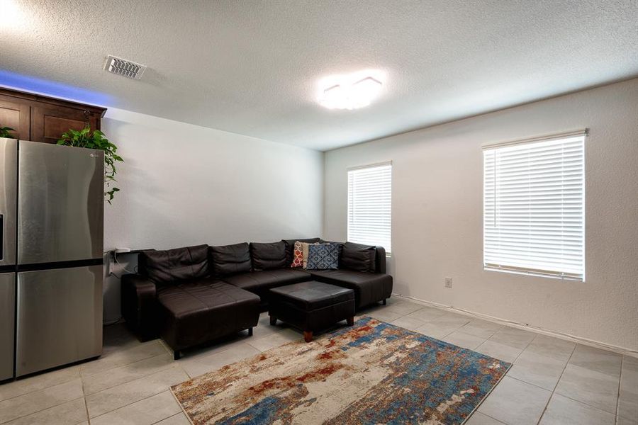 Living room featuring a textured ceiling and light tile patterned floors