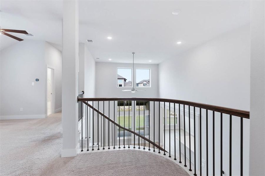 Upstairs landing and game room area with open railing and natural light.