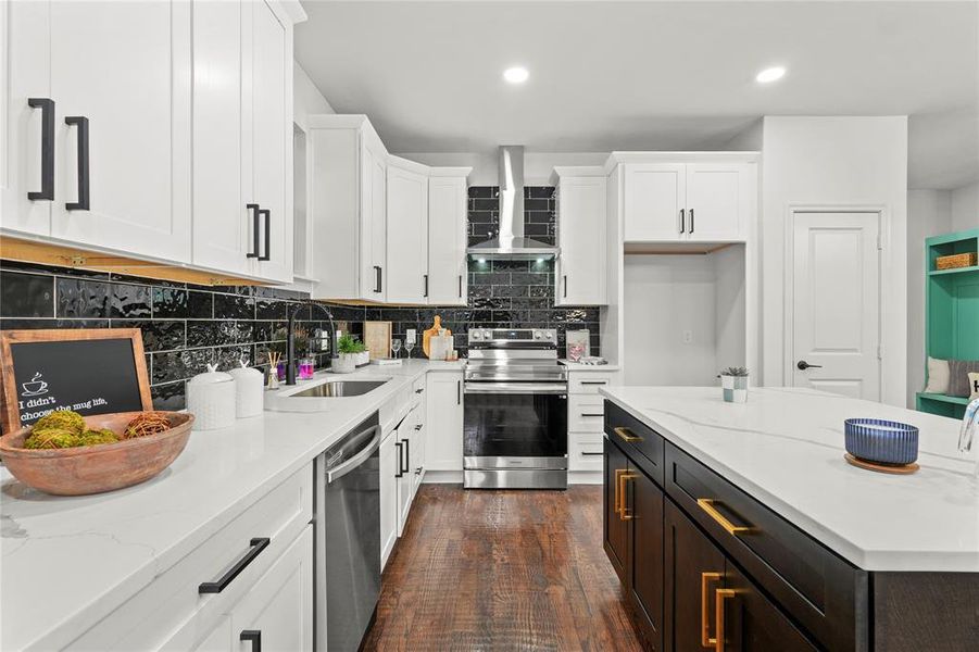 Kitchen with light stone countertops, stainless steel appliances, dark wood finished floors, two tone color scheme, and recessed lighting