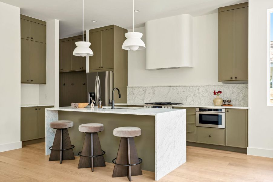 Culinary aspirations ignite in this well-appointed kitchen, featuring a central island with bar seating and light wood flooring.