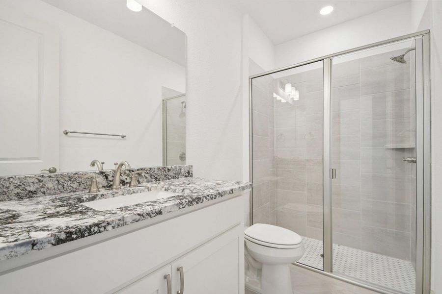 Bathroom featuring a stall shower, vanity, and recessed lighting Bathroom featuring a stall shower, vanity, and recessed lighting
