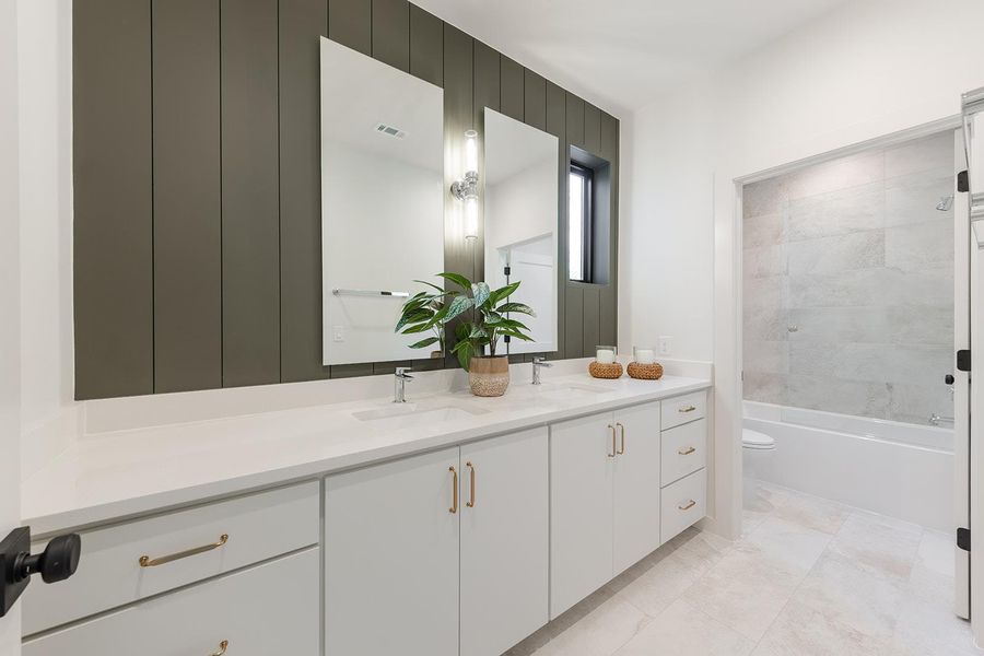 Bathroom with double vanity and bathtub / shower combination