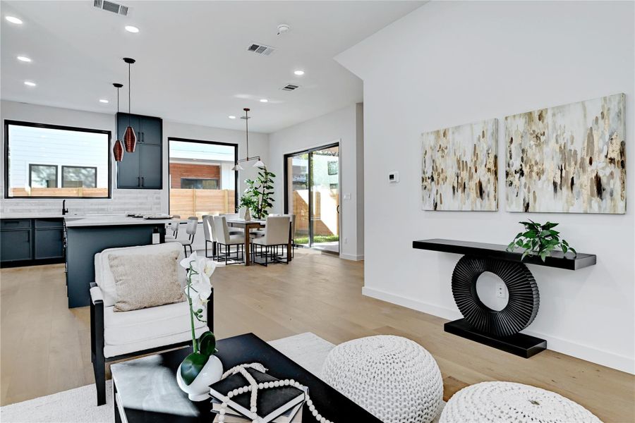 Living room with light wood-style flooring and recessed lighting