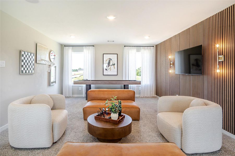 This inviting living space features modern decor with a cozy seating area, a stylish wood-paneled accent wall with a mounted TV, and large windows allowing for plenty of natural light. Perfect for relaxation and entertainment. This inviting living space features modern decor with a cozy seating area, a stylish wood-paneled accent wall with a mounted TV, and large windows allowing for plenty of natural light. Perfect for relaxation and entertainment.