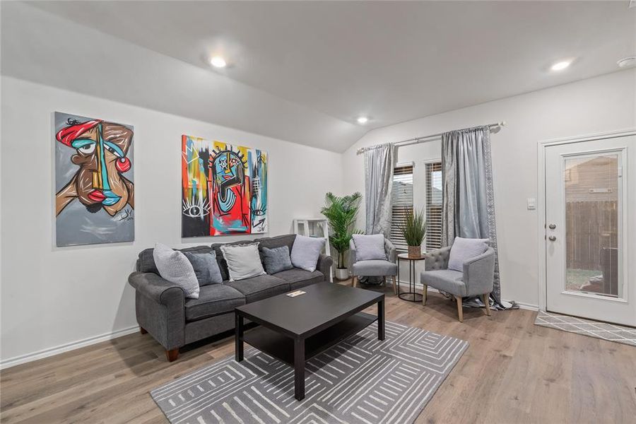 Living area with light wood finished floors, lofted ceiling, and recessed lighting