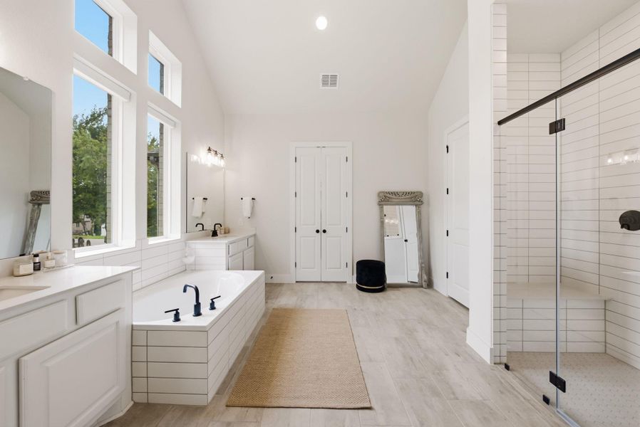 The primary ensuite bath offers a spa-like escape right at home, complete with separate vanities, a soaking tub and a large walk-in shower