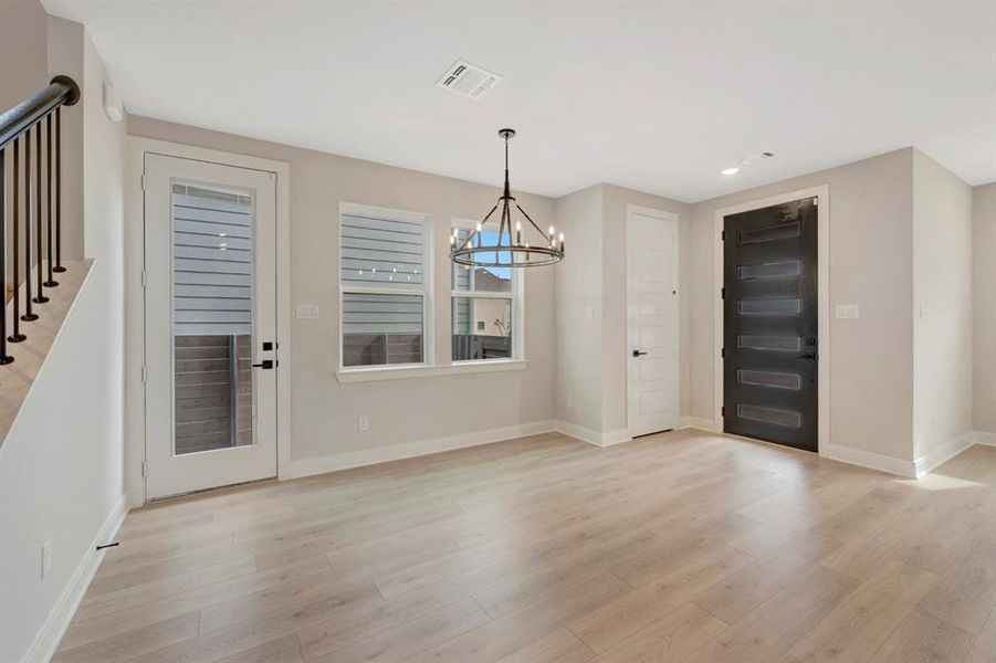 Foyer entrance featuring a chandelier and light wood-style flooring