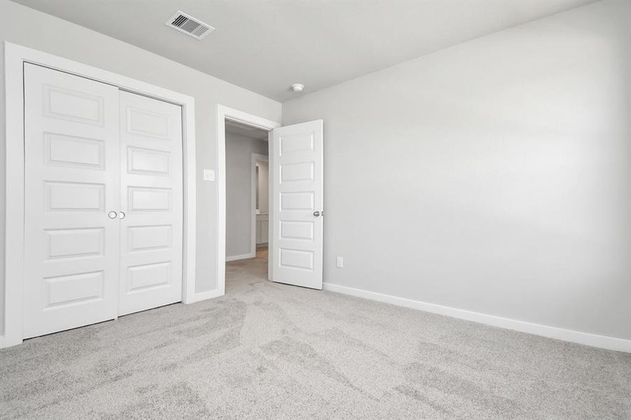 Generously sized secondary bedrooms, complete with spacious closets and soft, inviting carpeting.  Sample photo of completed home with similar plan. As built color and selections may vary.