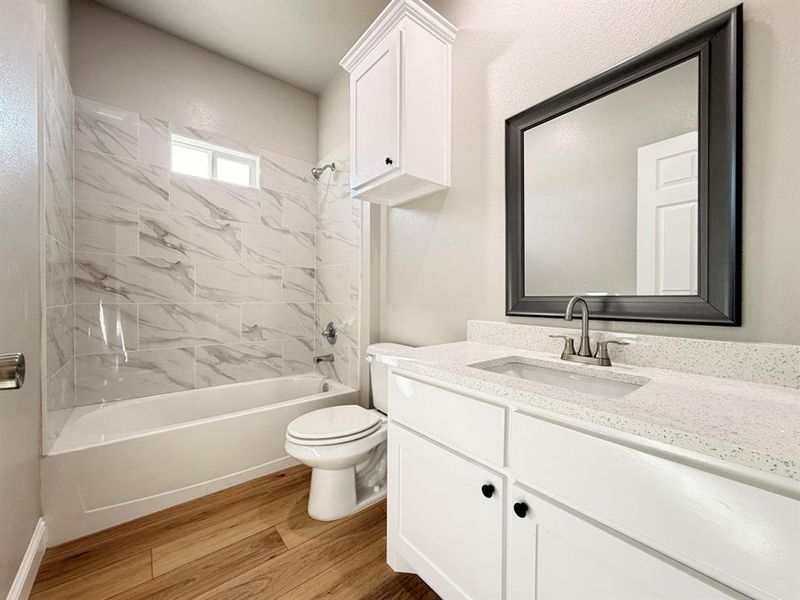 Full bath featuring vanity, shower combination, and light wood-type flooring Full bath featuring vanity, shower combination, and light wood-type flooring