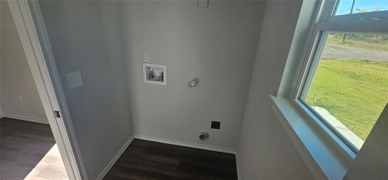 Laundry area with dark wood-style flooring, hookup for a washing machine, and hookup for an electric dryer