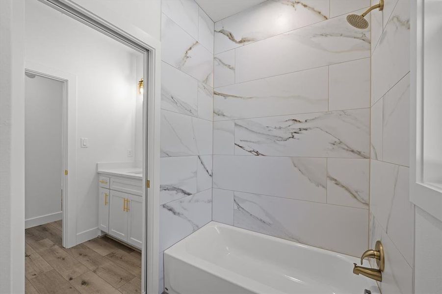 Bathroom with vanity, light wood-type flooring, and shower / washtub combination