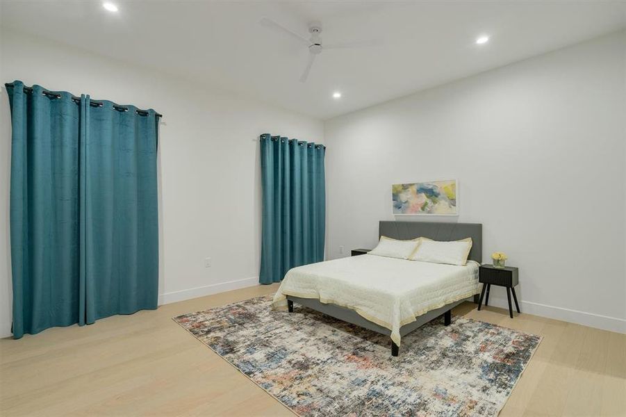 Bedroom with light wood-style floors, ceiling fan, and recessed lighting Bedroom with light wood-style floors, ceiling fan, and recessed lighting