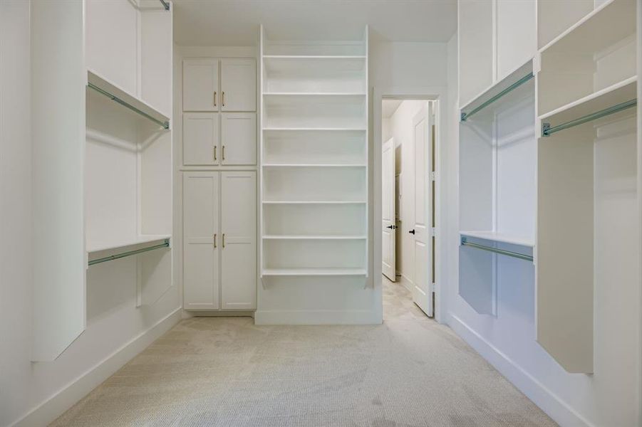 Walk in closet featuring light colored carpet Walk in closet featuring light colored carpet