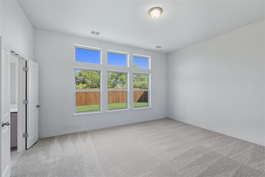Empty room with light carpet and baseboards Empty room with light carpet and baseboards