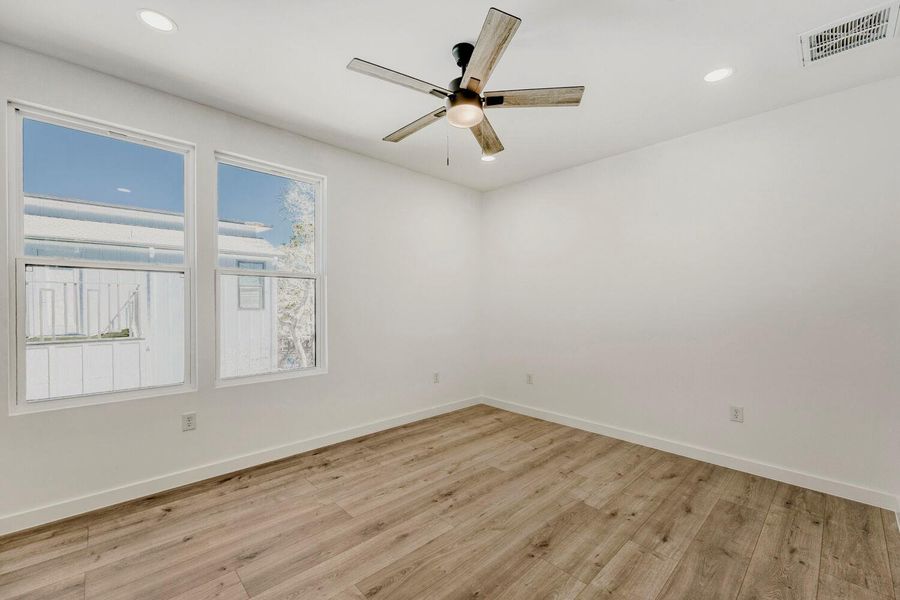 Unfurnished room featuring light wood-style flooring, ceiling fan, and recessed lighting