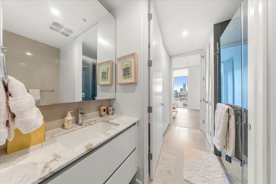 Secondary bath with modern finishes, a spacious vanity and glass-enclosed shower, with direct access to the den and the full-size washer and dryer. Secondary bath with modern finishes, a spacious vanity and glass-enclosed shower, with direct access to the den and the full-size washer and dryer.