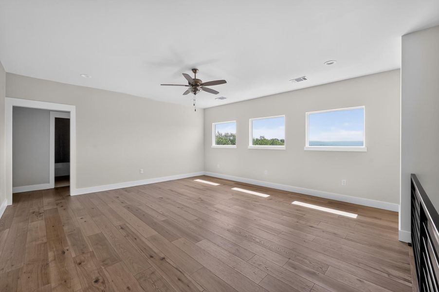 Rich wood flooring pairs beautifully with wide windows framing scenic distant views.