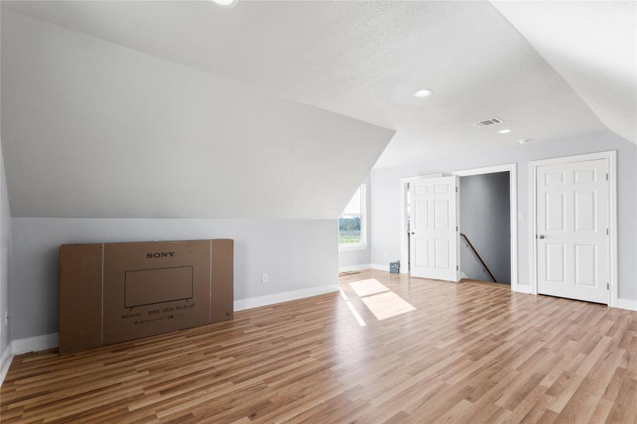 Your Needs for your Additional living space featuring vaulted ceiling, light wood-style flooring, and recessed lighting