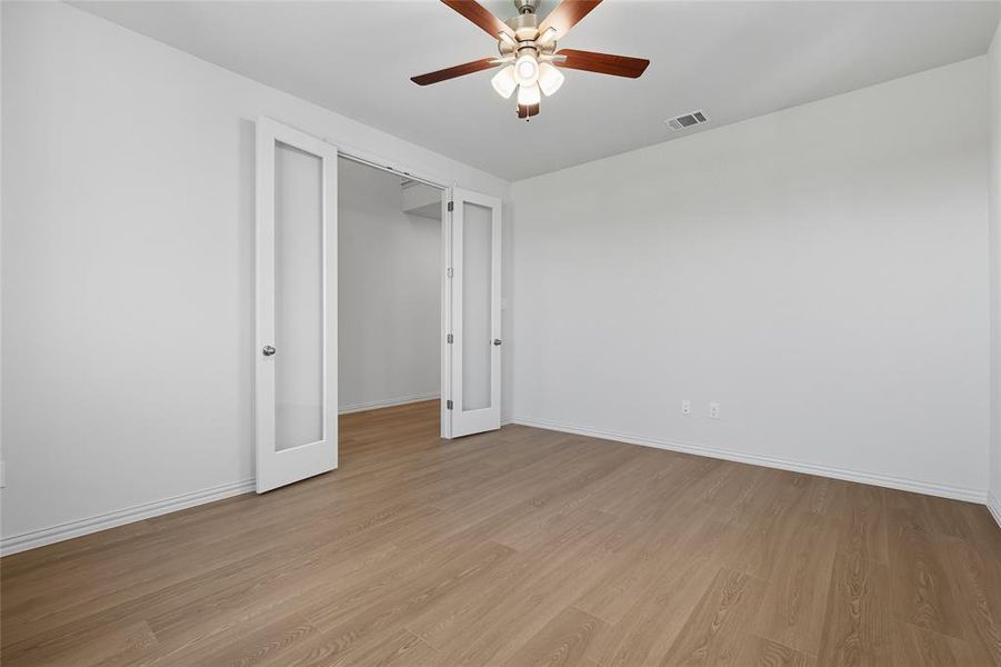 Unfurnished bedroom featuring light wood-type flooring and ceiling fan Unfurnished bedroom featuring light wood-type flooring and ceiling fan