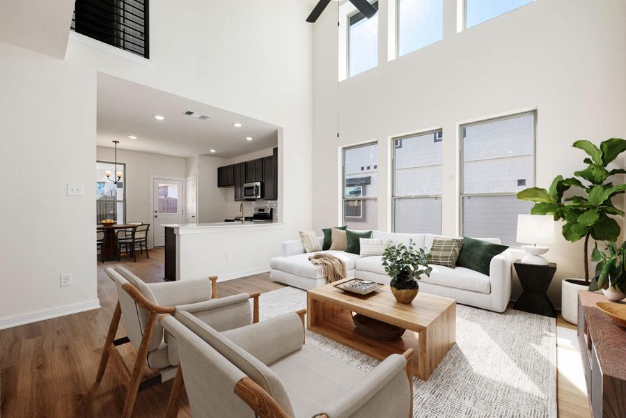 This inviting living space features soaring ceilings and an abundance of natural light streaming through large picture windows. The open-concept layout seamlessly connects the living area to the kitchen and dining spaces, creating a bright and airy atmosphere. With neutral tones, wood-look flooring, and modern finishes, this room offers both warmth and style, perfect for everyday living and relaxation. This inviting living space features soaring ceilings and an abundance of natural light streaming through large picture windows. The open-concept layout seamlessly connects the living area to the kitchen and dining spaces, creating a bright and airy atmosphere. With neutral tones, wood-look flooring, and modern finishes, this room offers both warmth and style, perfect for everyday living and relaxation.