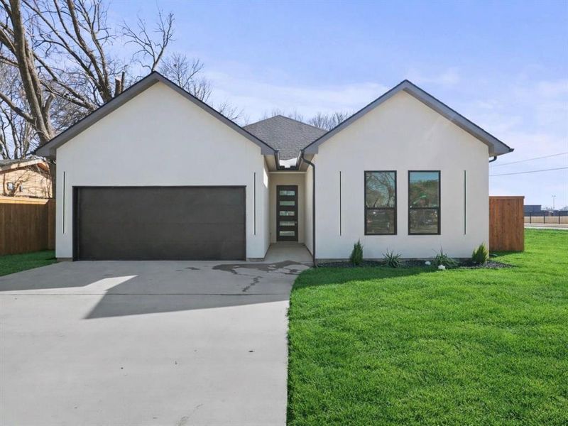 View of front facade featuring an attached garage, stucco siding, and driveway View of front facade featuring an attached garage, stucco siding, and driveway