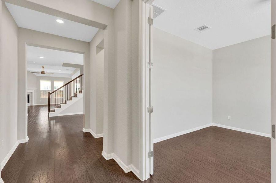 Hallway with dark wood-style flooring, stairs, and recessed lighting Hallway with dark wood-style flooring, stairs, and recessed lighting