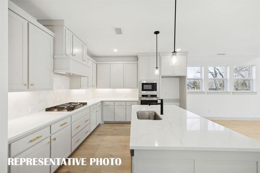 Beautiful cabinetry, gorgeous countertops and designer backsplash effortlessly pair with contemporary stainless steel to create a kitchen for the ages!  REPRESENTATIVE PHOTO