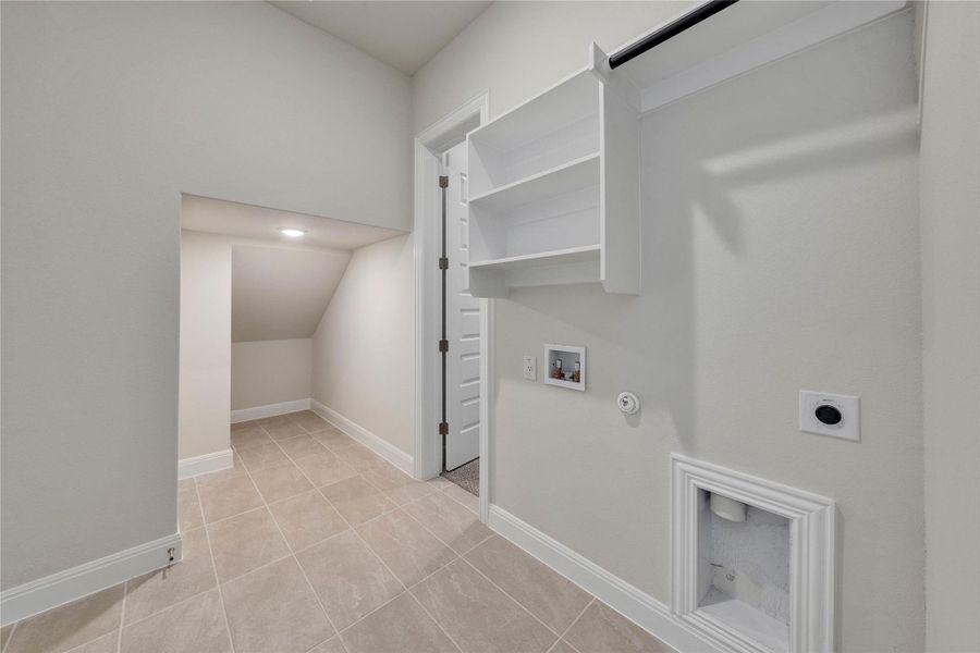 Laundry room with gas dryer hookup, electric dryer hookup, washer hookup, and light tile patterned floors Laundry room with gas dryer hookup, electric dryer hookup, washer hookup, and light tile patterned floors