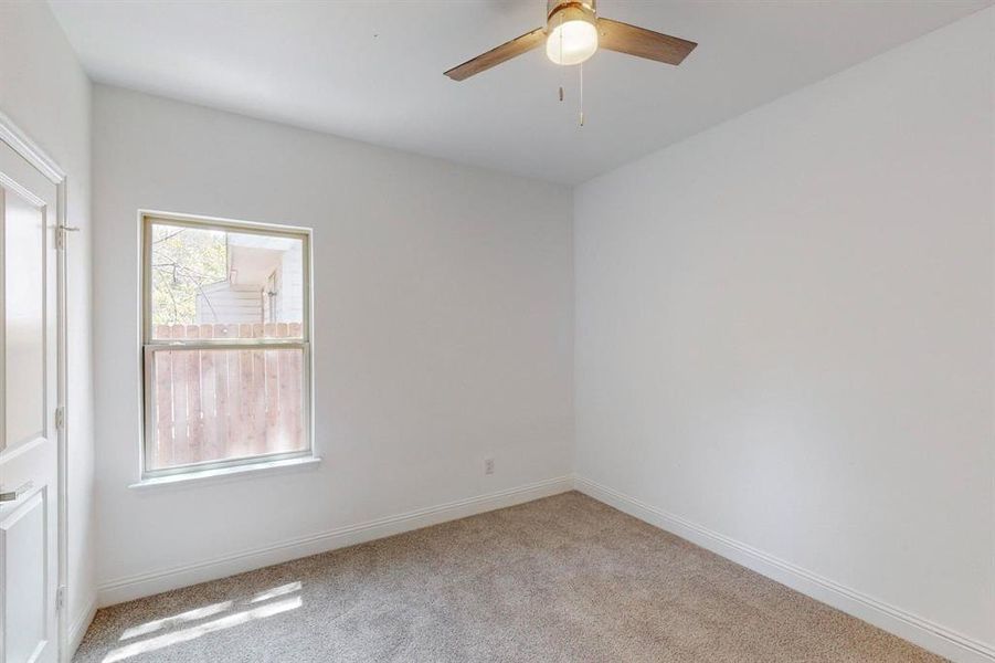 Empty room featuring light colored carpet and ceiling fan