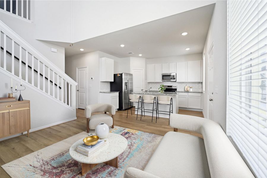 Living room with light wood-style flooring and recessed lighting