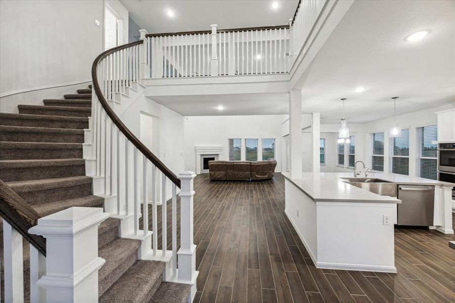 Marvel at the stunning curved staircase that serves as a captivating focal point, open to both the kitchen and family room. This elegant design not only enhances the home’s grandeur but also creates a sense of connectivity throughout the living spaces, making it perfect for entertaining and family interactions.