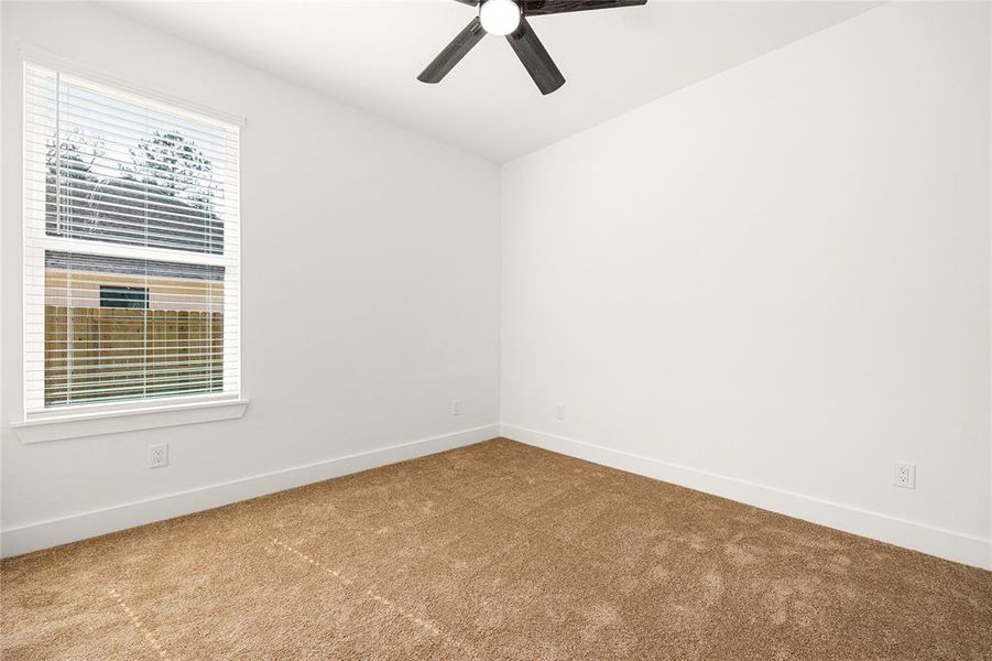 Bright and Cozy BedroomThis inviting bedroom features plush carpeting, a modern ceiling fan, and a spacious double-door closet. The neutral color palette and natural light create a warm and comfortable space, perfect for relaxation