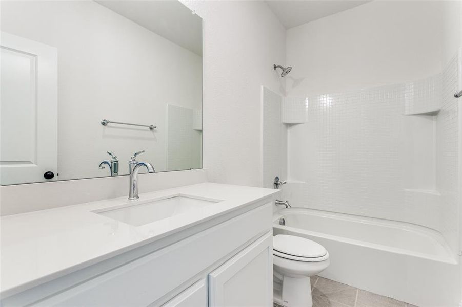 Full bathroom with tile flooring,  shower combination, vanity, and toilet