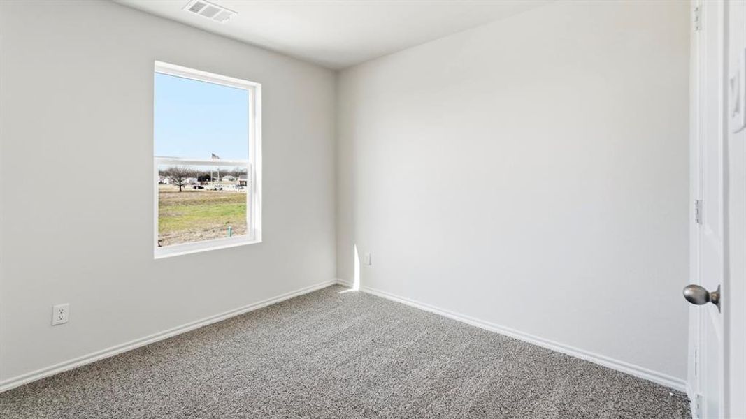 Carpeted spare room with baseboards