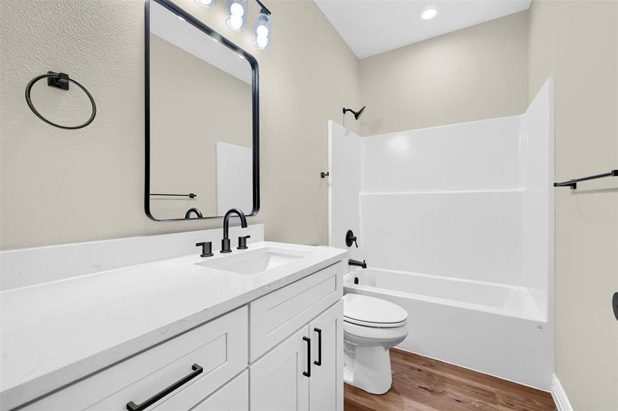 Full bathroom with vanity, shower / bathtub combination, toilet, and wood-type flooring