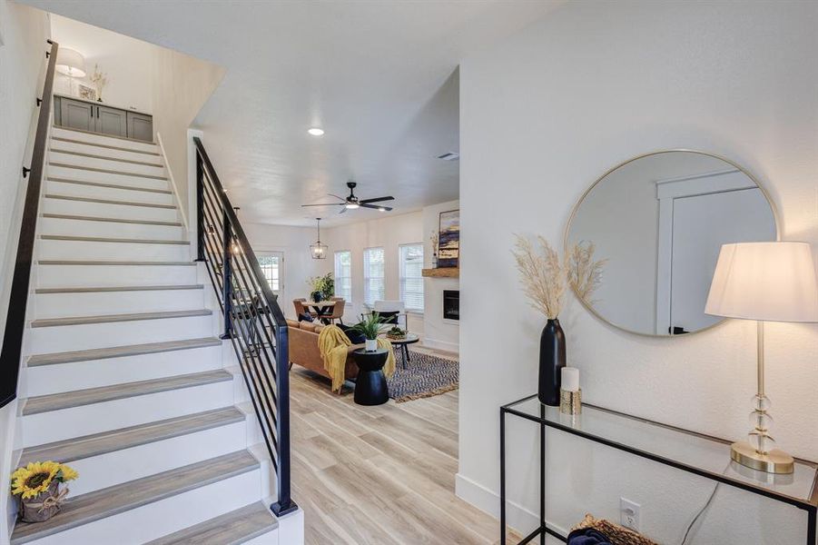 Stairway with wood-type flooring and ceiling fan