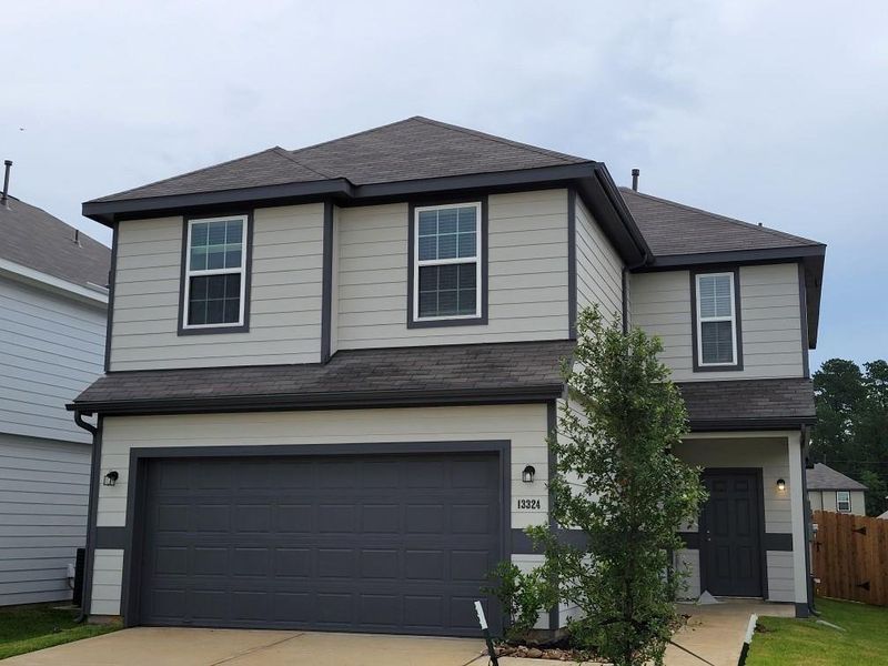 Front exterior of a new home in River's Edge, Conroe, TX, highlighting curb appeal (Image 1). Front exterior of a new home in River's Edge, Conroe, TX, highlighting curb appeal (Image 1).