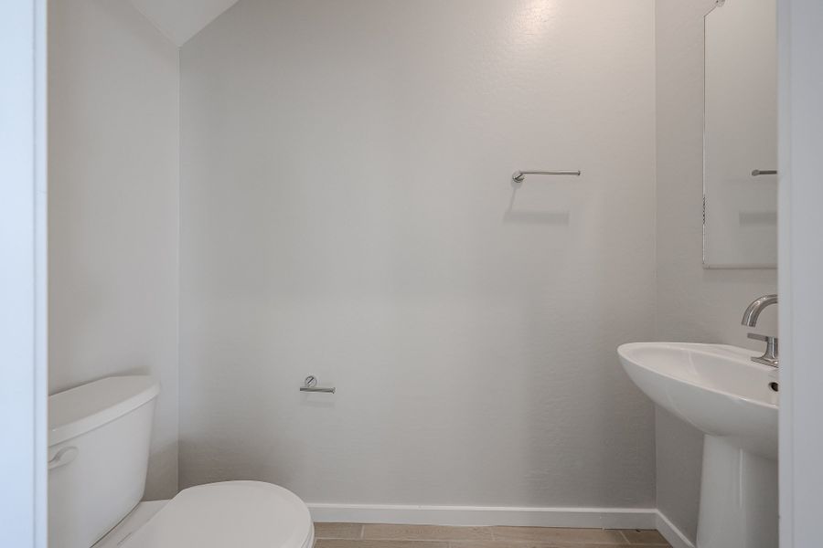 A bathroom with a toilet and sink. A bathroom with a toilet and sink.