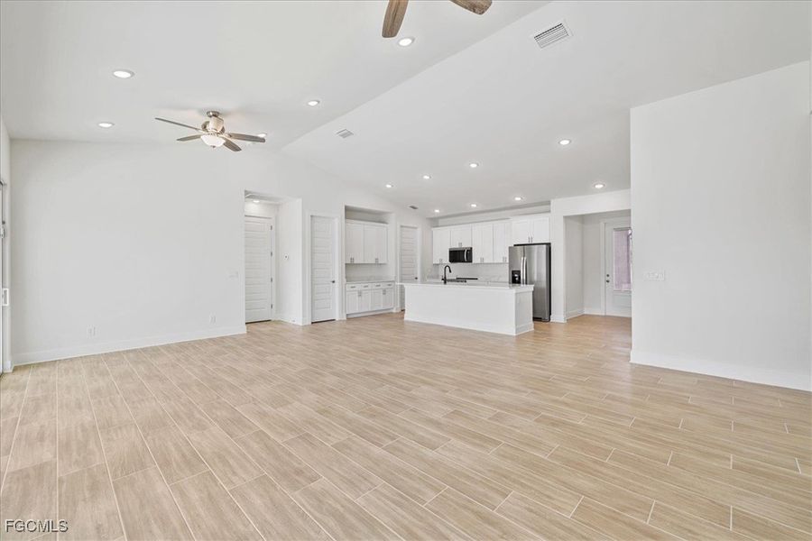 Unfurnished living room featuring recessed lighting, a ceiling fan, lofted ceiling, and wood finish floors