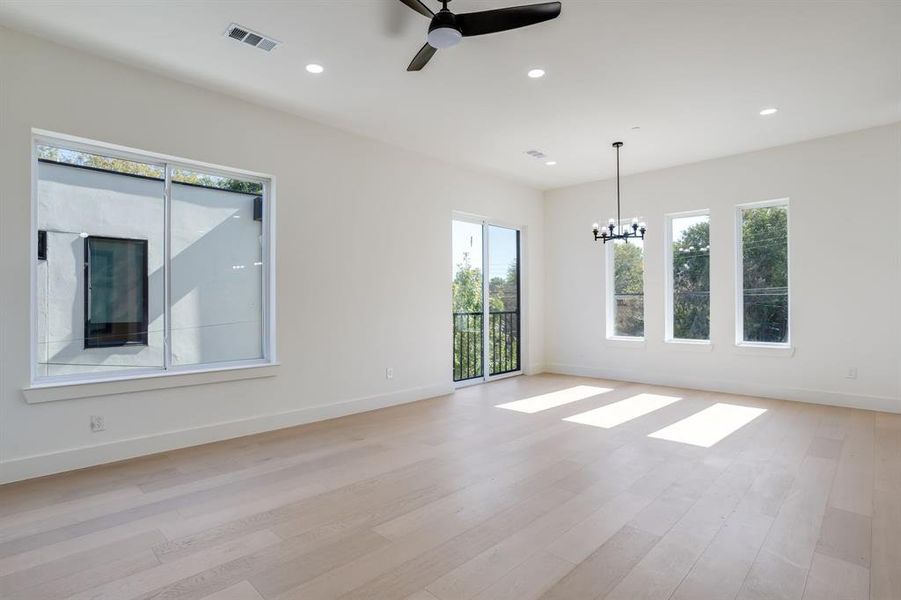 Empty room with recessed lighting, light wood-style flooring, ceiling fan, and a chandelier