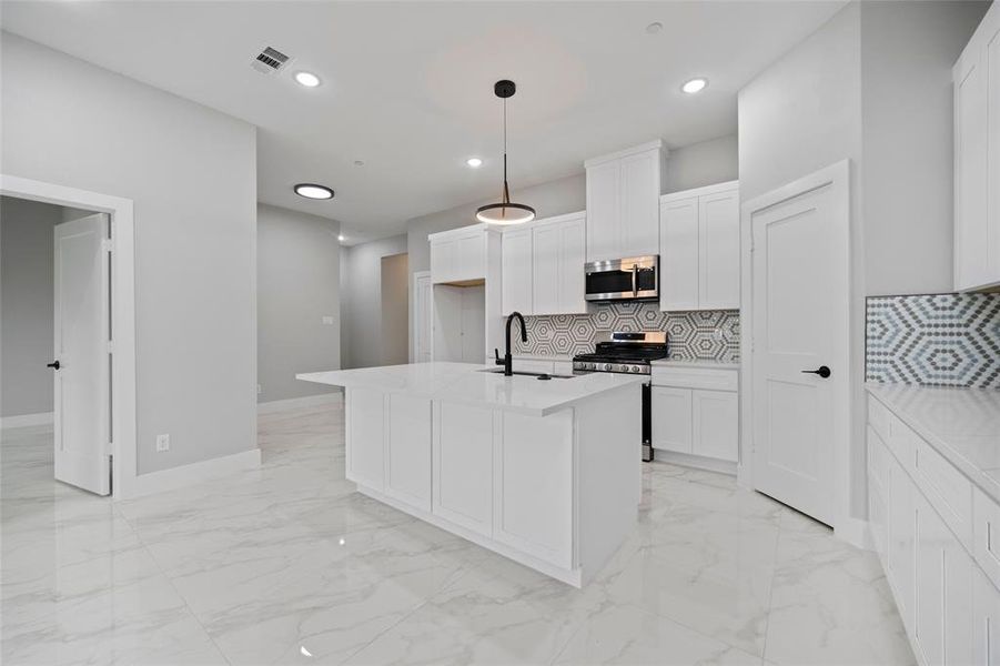 Kitchen with visible vents, marble finish floor, stainless steel appliances, and decorative backsplash