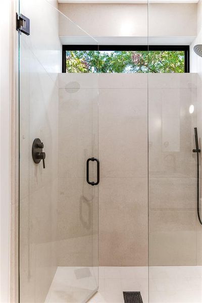 Bathroom with a shower stall and plenty of natural light