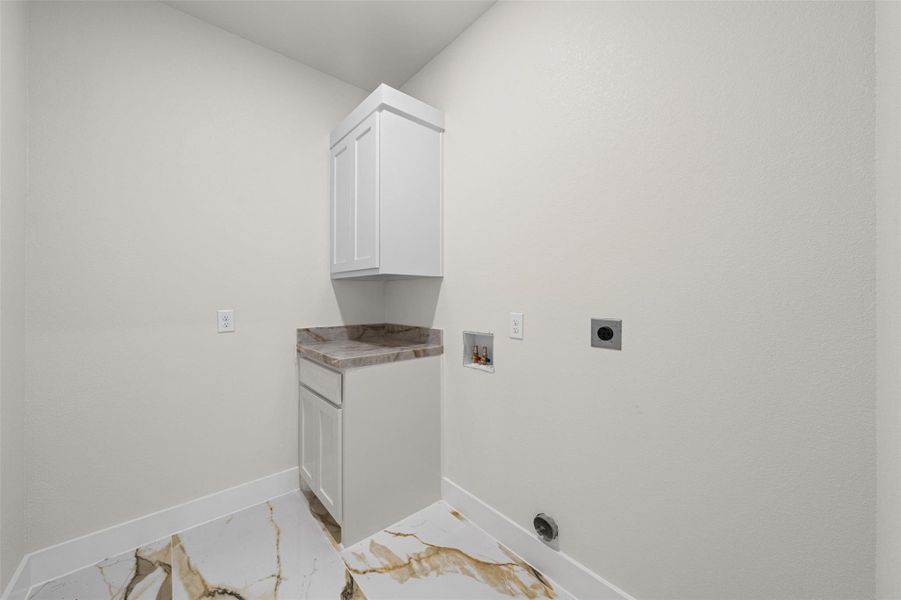 Functional utility space highlights modern cabinetry, stone countertops, and polished tile flooring.