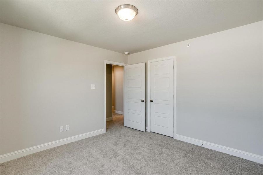 Unfurnished bedroom featuring light carpet and a closet