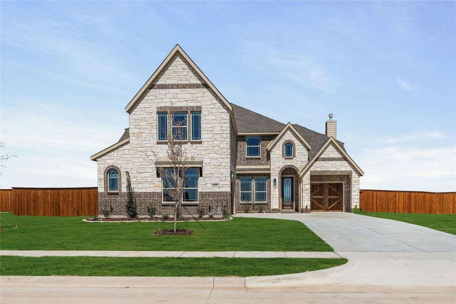 Two-story home with stone and brick exterior, arched entry, two-car garage, and green front lawn Two-story home with stone and brick exterior, arched entry, two-car garage, and green front lawn
