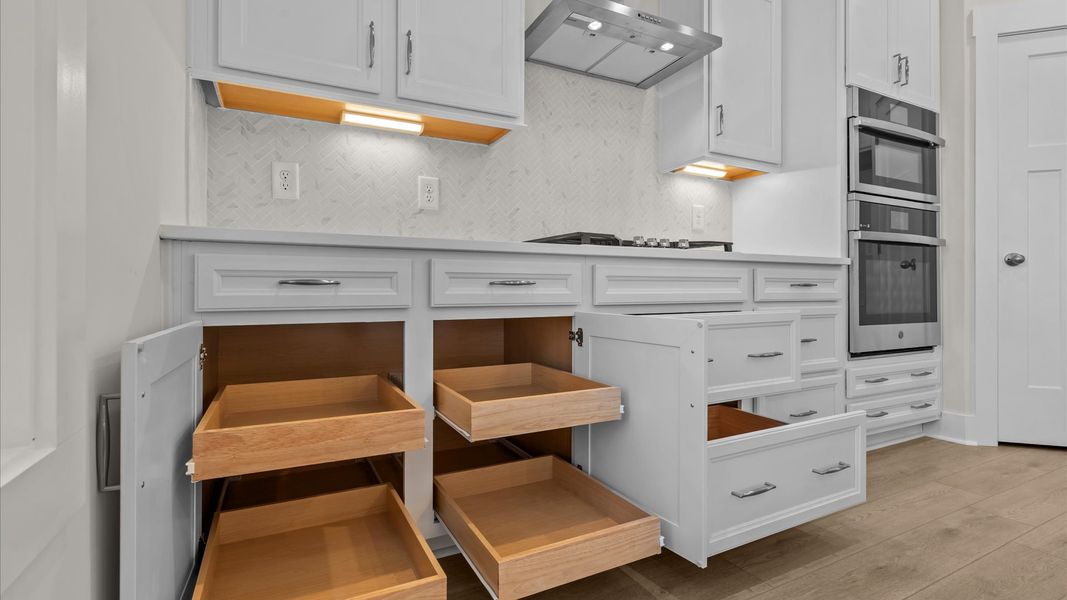 Elegant kitchen with large island and pendant lighting in this first-class DRB Homes design